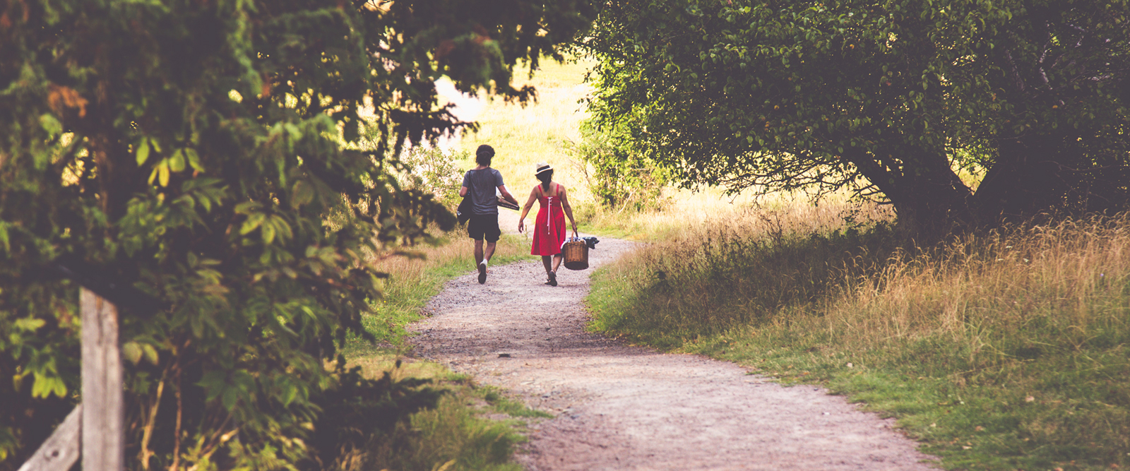 couple on picnick strolling along park path and trees