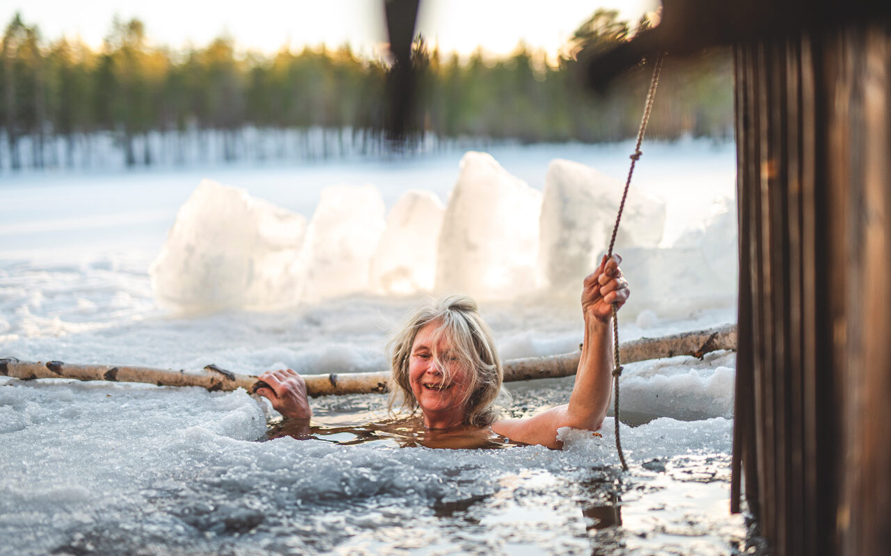 woman ice bathing holding a security rope in the winter
