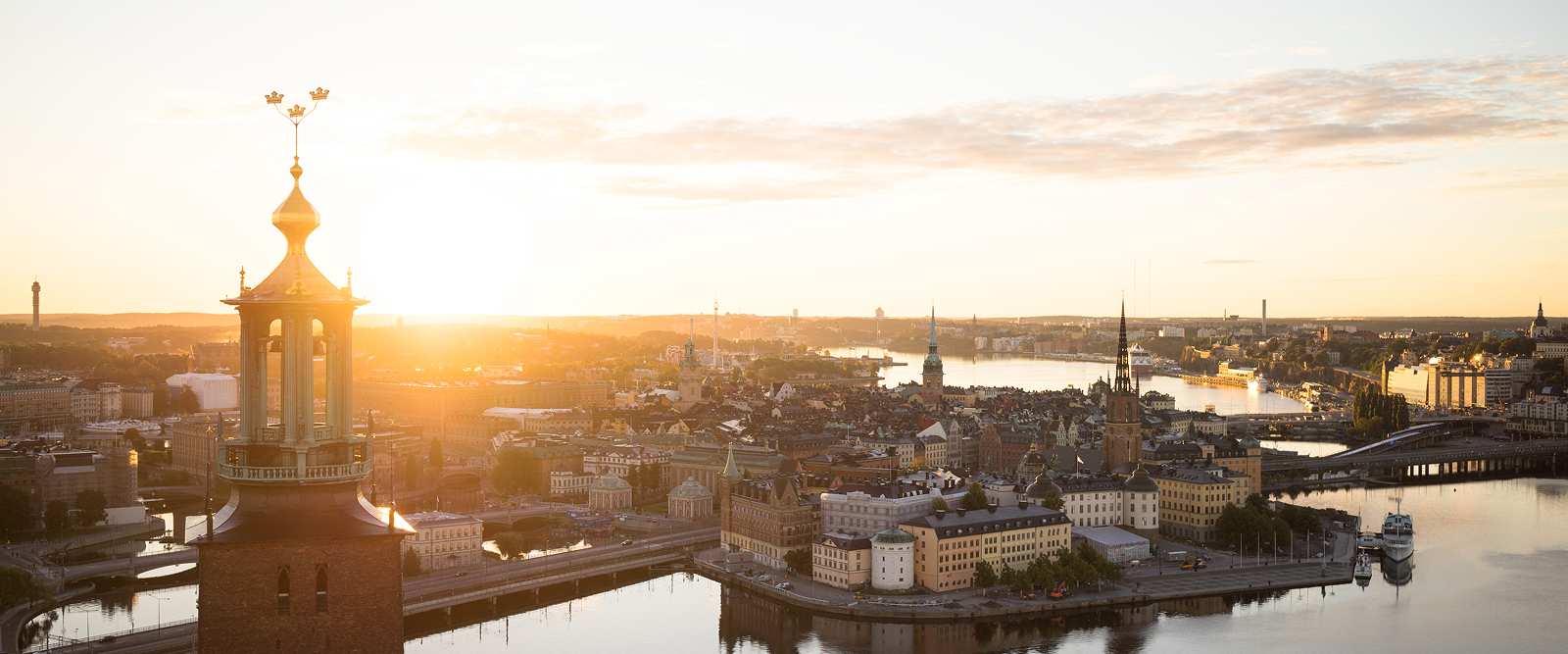 skyline in stockholm with sun low on the horizon with tower in the foreground